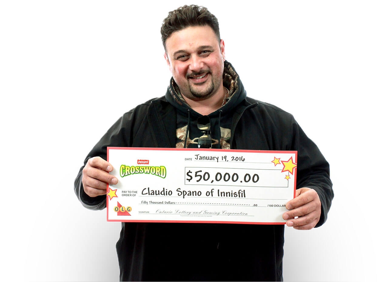 Man holding 50,000 dollar cheque from winning instant crossword