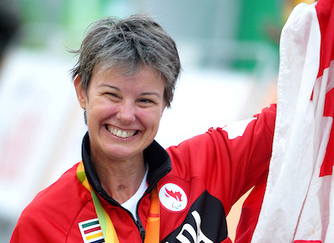 La paracycliste de compétition Shelley Gautier, tenant un drapeau canadien lors des Jeux olympiques de Rio 2016.