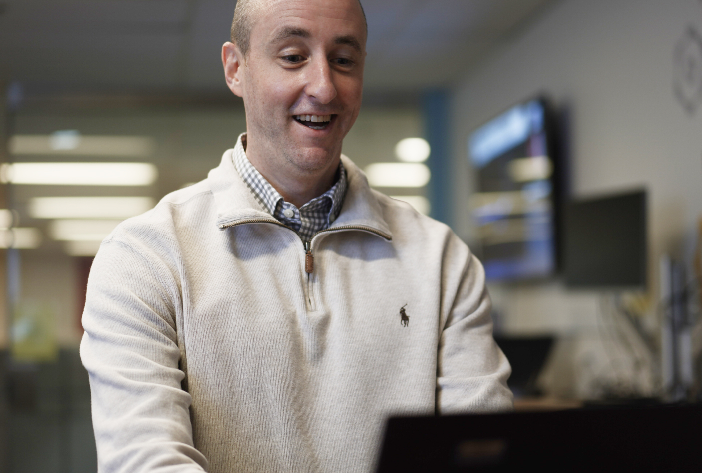 OLG employee smiling while working on computer