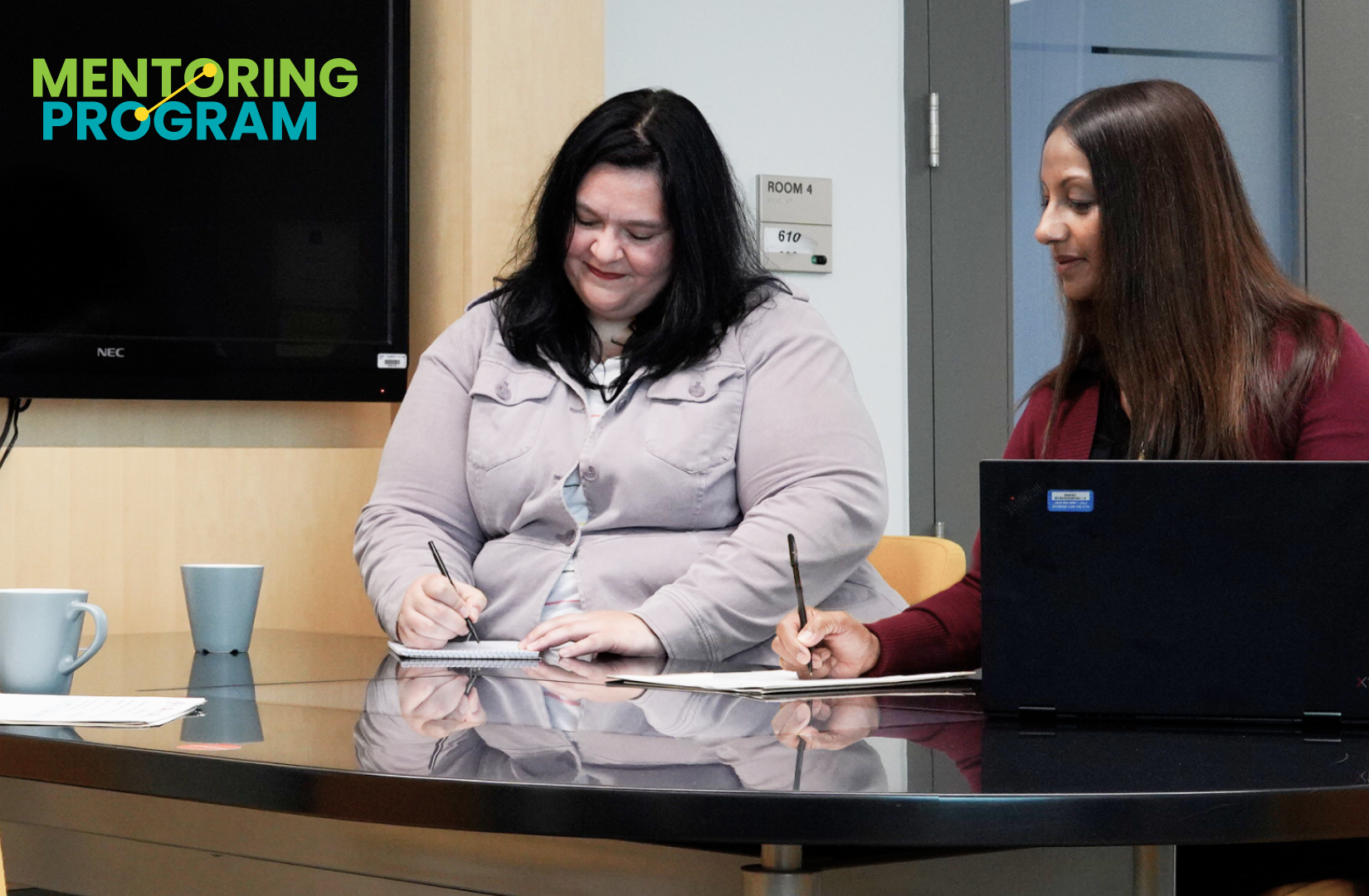 Two OLG employees working together at desk