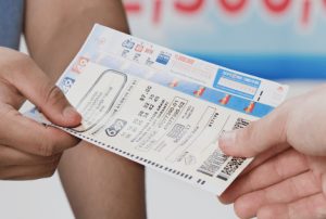 Two hands holding an OLG lotto 649 lottery ticket, winning tickets