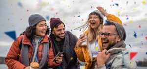 Groupe de quatre personnes heureuses qui viennent de gagner à un jeu de loterie d'OLG, entourées de confettis.