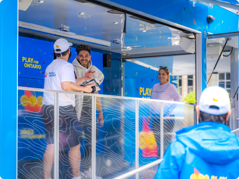 A group of people standing in an OLG Festival Tour booth.