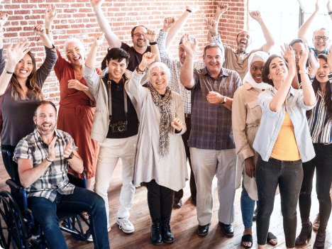 Group of people standing while waving and clapping.