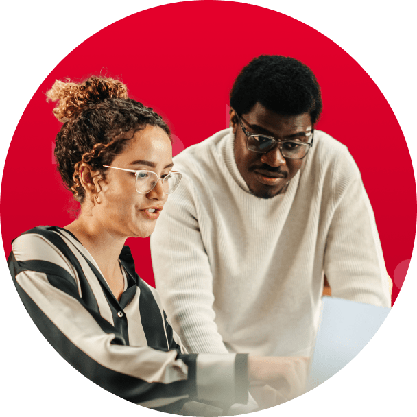 Two people staring at a computer screen looking engaged.