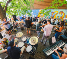 View of a small concert with several musical instruments and a crowd in view.