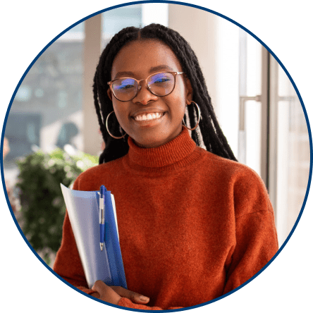 A person wearing glasses holding a blue folder smiling