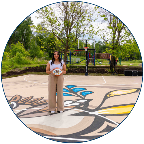 Emily Mandamin Standing on Fully Refurbished Basketball Court