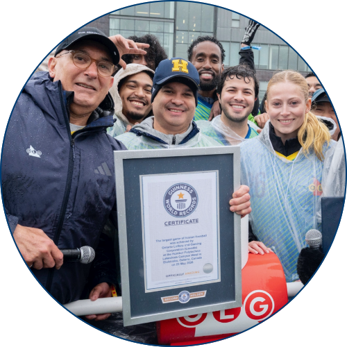 Un groupe de personnes célébrant et détenant le certificat encadré du GUINNESS WORLD RECORDS™.